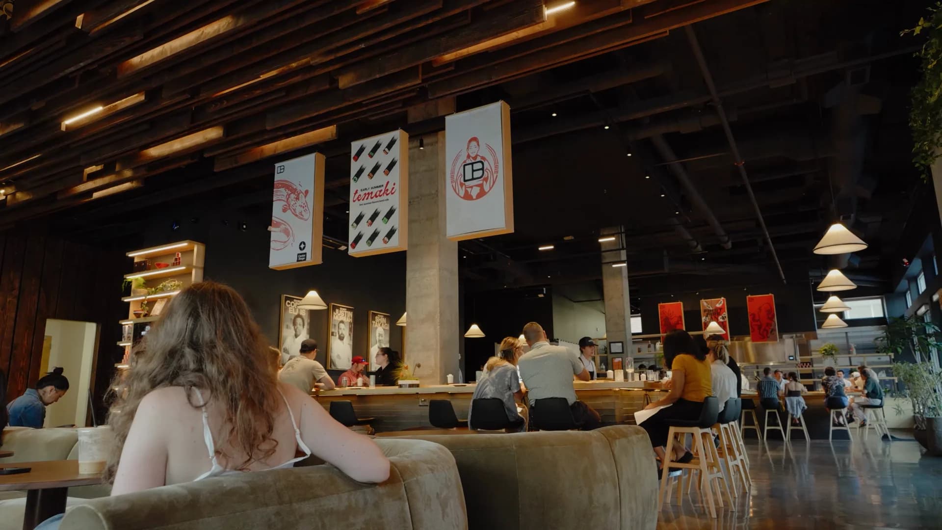 Interior of Bentoville Food Theater with guests seated at the bar counter beneath hanging banners