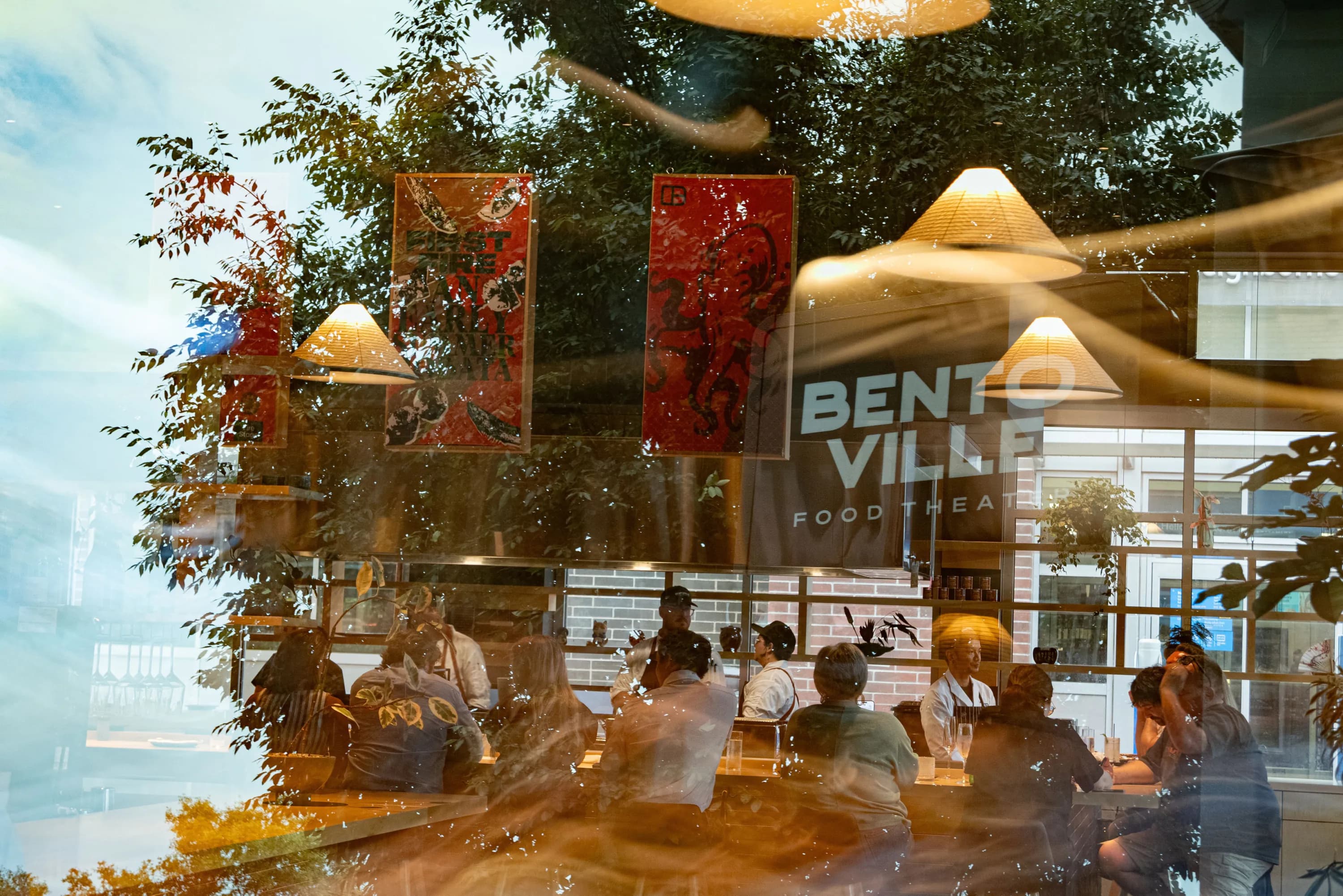 Guests dining at Bentoville Food Theater, seen through the storefront window